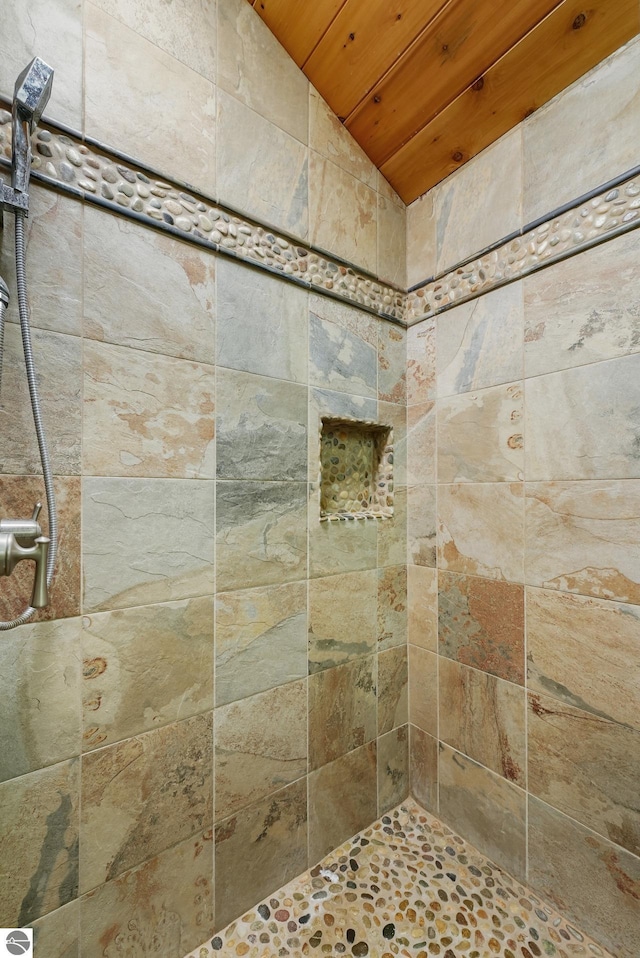 bathroom with a tile shower, wooden ceiling, and vaulted ceiling