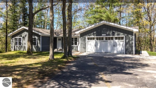 single story home with a garage and a front lawn