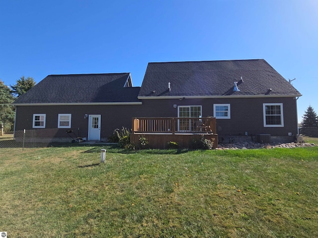 rear view of property featuring a deck and a yard