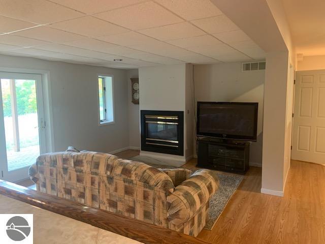 living room featuring a paneled ceiling and hardwood / wood-style flooring