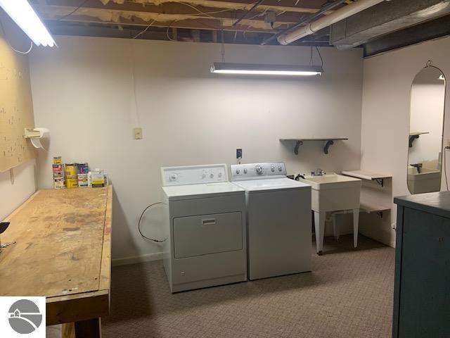 clothes washing area featuring washer and dryer and dark carpet