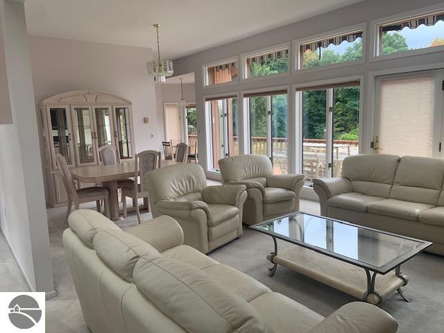 carpeted living room featuring a chandelier and plenty of natural light