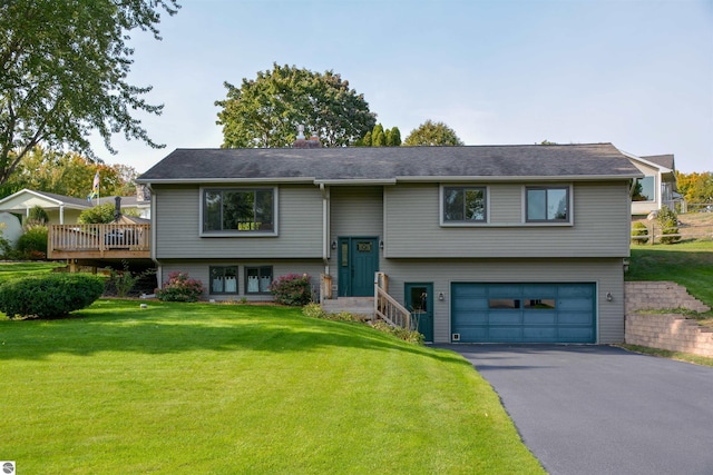 bi-level home with a wooden deck, a front yard, and a garage