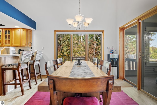 dining room with a healthy amount of sunlight, an inviting chandelier, and light hardwood / wood-style flooring