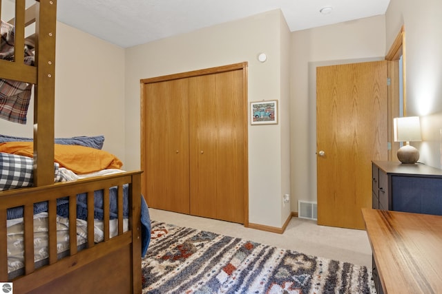 bedroom with light carpet and a closet