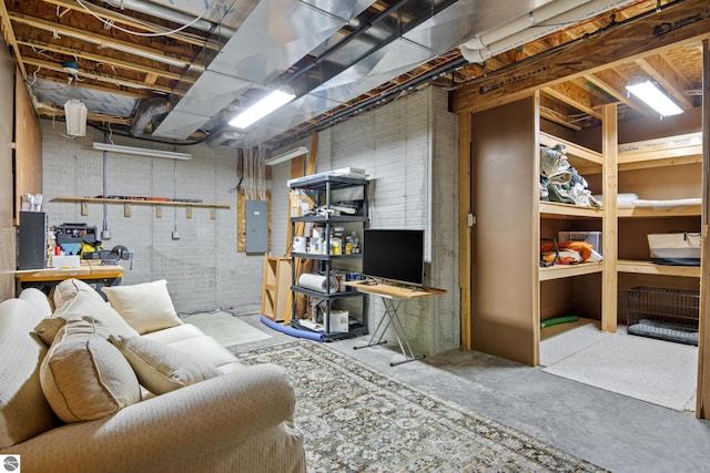 basement with brick wall, electric panel, and a workshop area