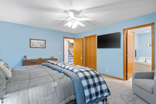 bedroom featuring ceiling fan, connected bathroom, and light colored carpet