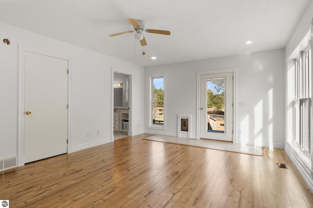 unfurnished living room with light wood-type flooring and ceiling fan