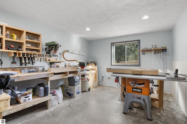 interior space with a textured ceiling, concrete flooring, and a workshop area