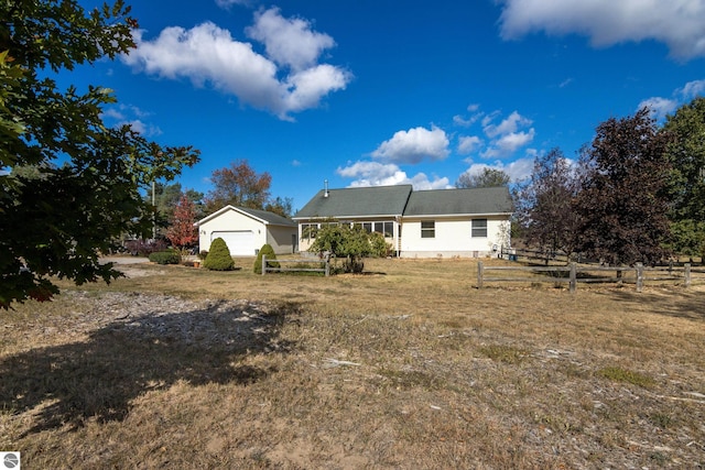 rear view of property featuring a garage and a lawn