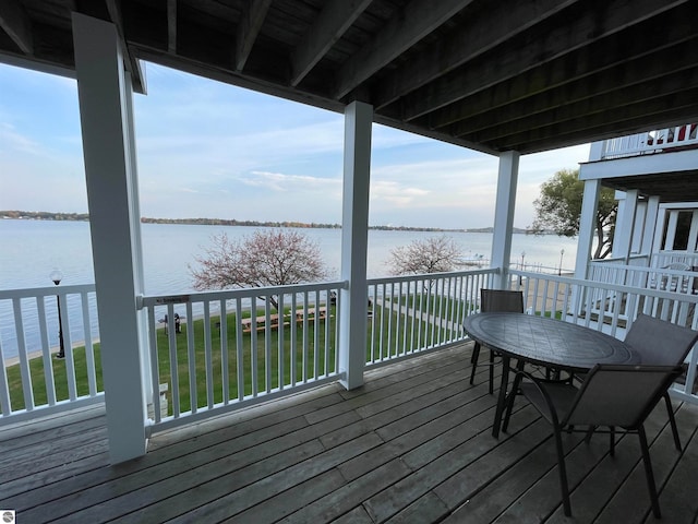 deck featuring a water view and a lawn