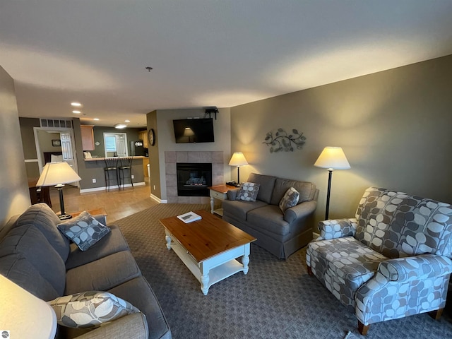 living room with carpet and a tile fireplace