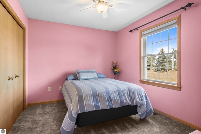 carpeted bedroom featuring ceiling fan and a closet