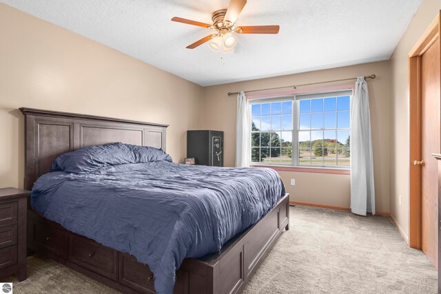 carpeted bedroom featuring a textured ceiling and ceiling fan