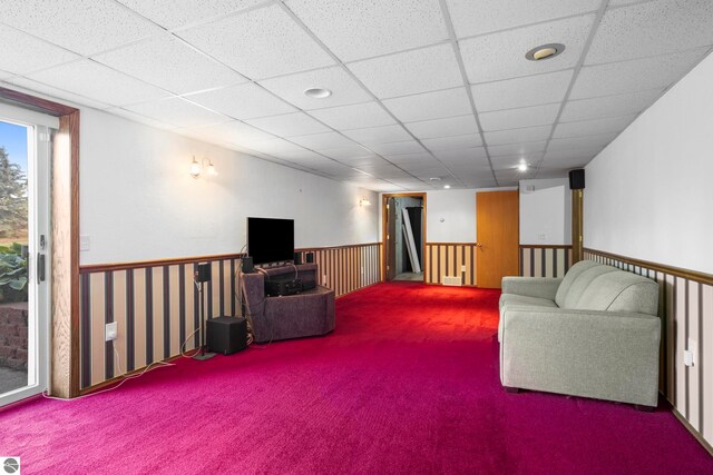 carpeted living room featuring a drop ceiling