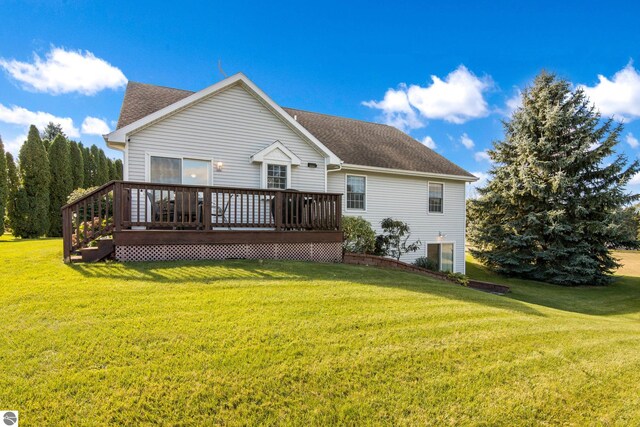 rear view of property featuring a wooden deck and a lawn