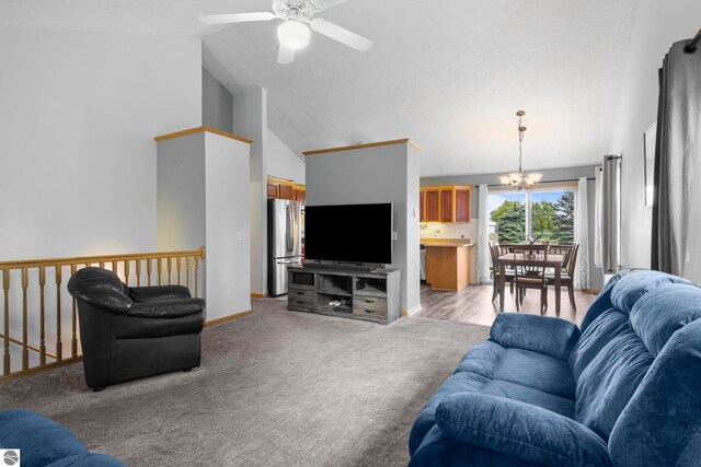 carpeted living room with ceiling fan with notable chandelier and high vaulted ceiling