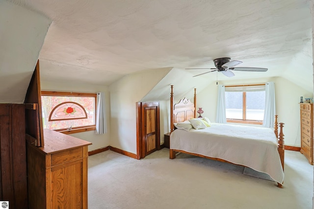 bedroom with lofted ceiling, light colored carpet, multiple windows, and ceiling fan