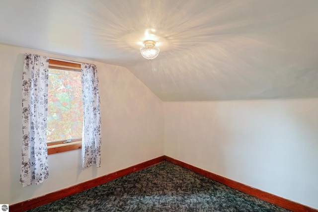 additional living space featuring lofted ceiling and carpet