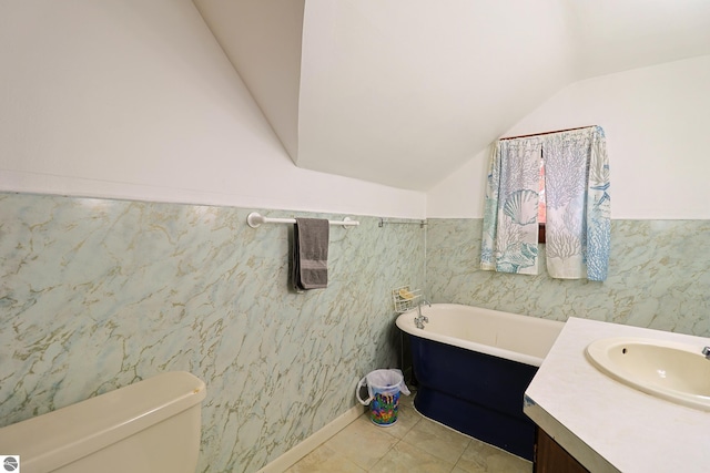 bathroom with vanity, a bathtub, toilet, tile patterned floors, and vaulted ceiling