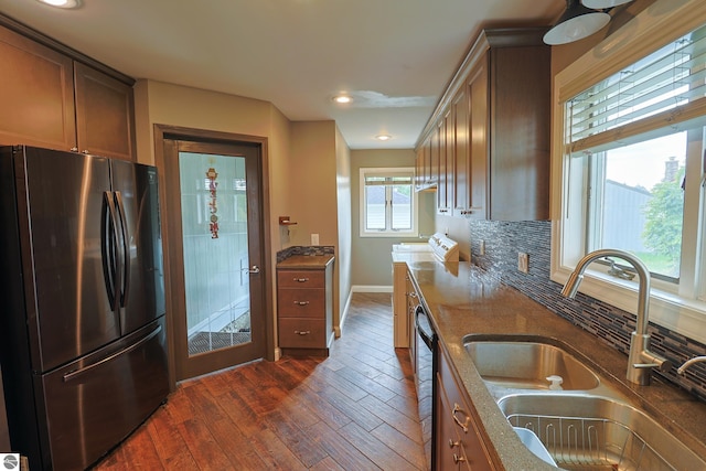 kitchen featuring dark hardwood / wood-style floors, tasteful backsplash, washer and clothes dryer, sink, and appliances with stainless steel finishes