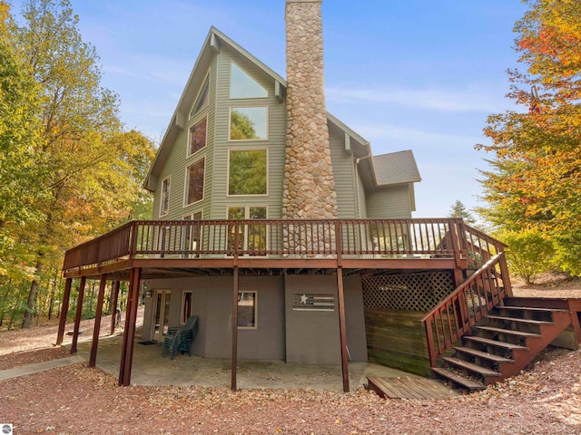 rear view of property featuring a deck and a patio