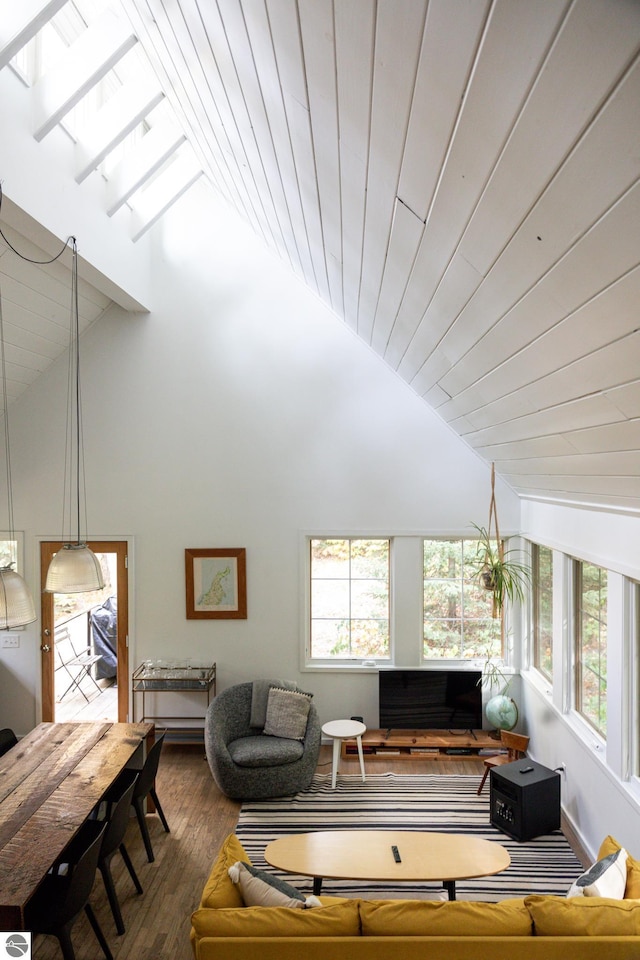 living room with dark hardwood / wood-style flooring, high vaulted ceiling, and a wealth of natural light