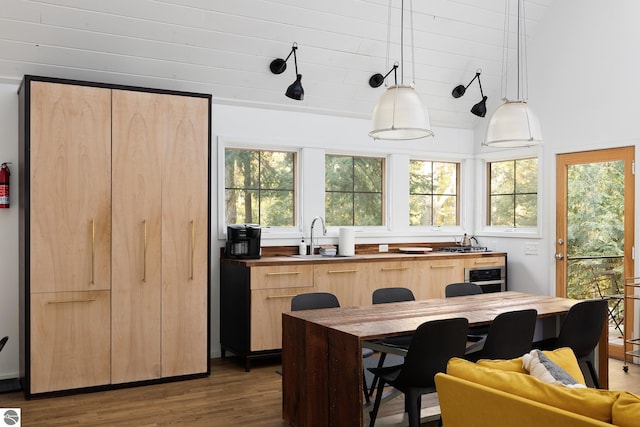 kitchen featuring wood-type flooring, pendant lighting, light brown cabinets, and sink