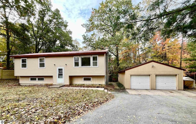 split foyer home featuring a garage and an outbuilding