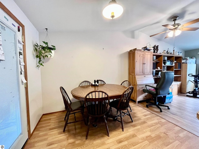 dining space featuring ceiling fan, lofted ceiling, built in desk, and light hardwood / wood-style floors