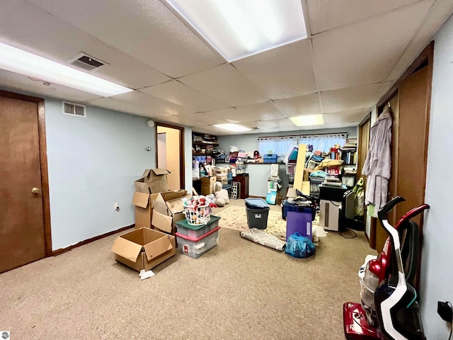 basement with carpet floors and a drop ceiling