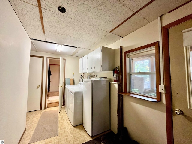 laundry room with washer and clothes dryer and cabinets