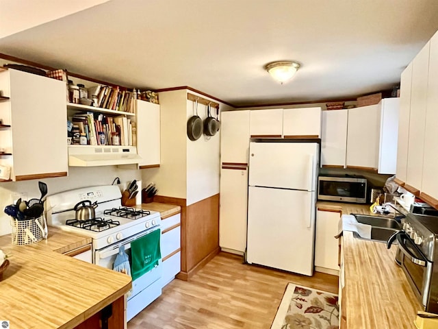 kitchen featuring ventilation hood, white cabinets, appliances with stainless steel finishes, and light hardwood / wood-style flooring