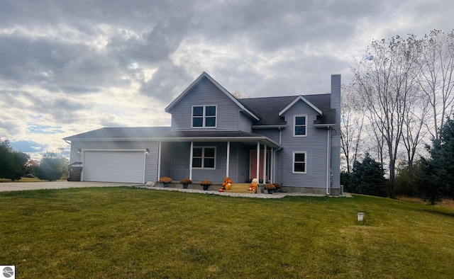 view of front of property featuring covered porch, a garage, and a front yard