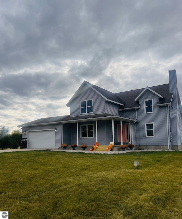 view of front of home featuring covered porch, a garage, and a front lawn