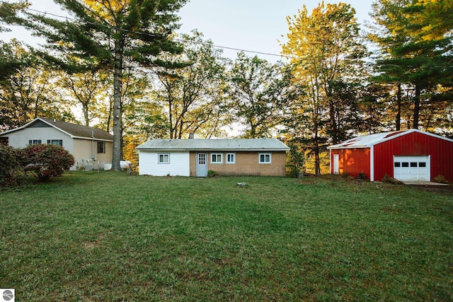 exterior space with a garage, an outbuilding, and a lawn