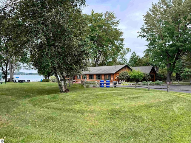 log-style house with a water view and a front lawn