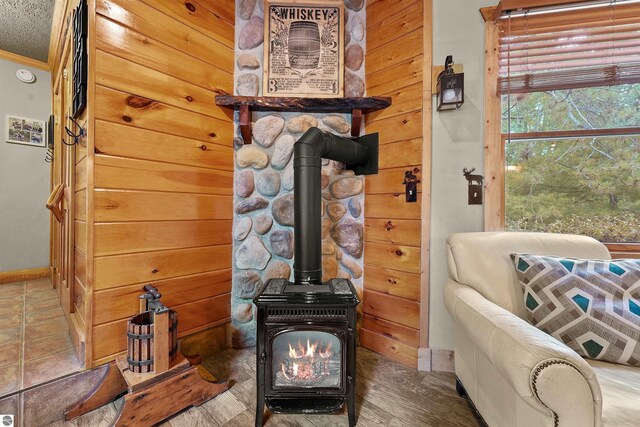 sitting room with hardwood / wood-style floors, a textured ceiling, and a wood stove