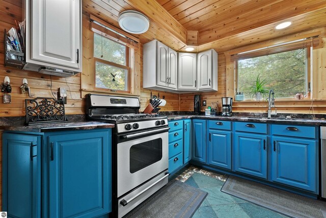 kitchen with blue cabinetry, white cabinets, stainless steel range with gas cooktop, and a healthy amount of sunlight