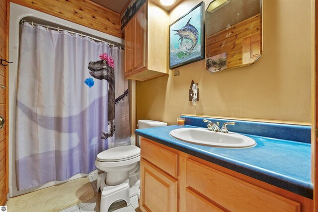 bathroom featuring tile patterned flooring, a shower with curtain, vanity, and toilet