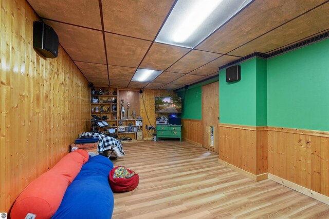 game room featuring wooden walls and light wood-type flooring