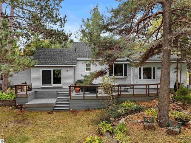 back of property featuring a yard and a wooden deck