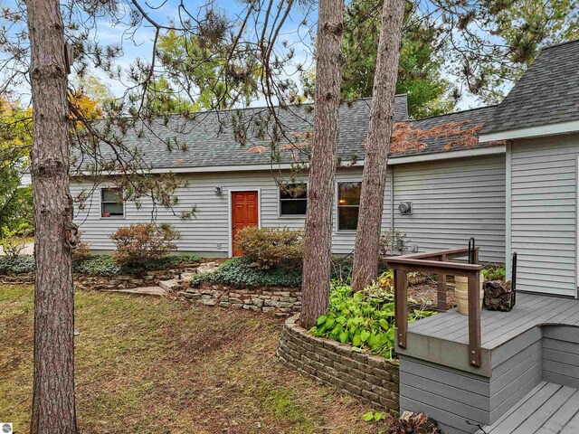 rear view of property featuring a wooden deck