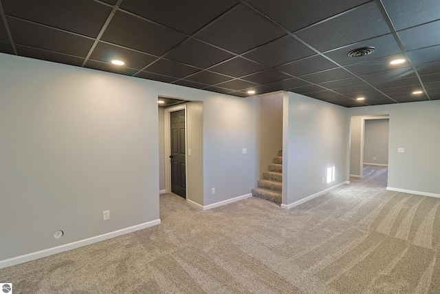 basement featuring a drop ceiling and carpet flooring