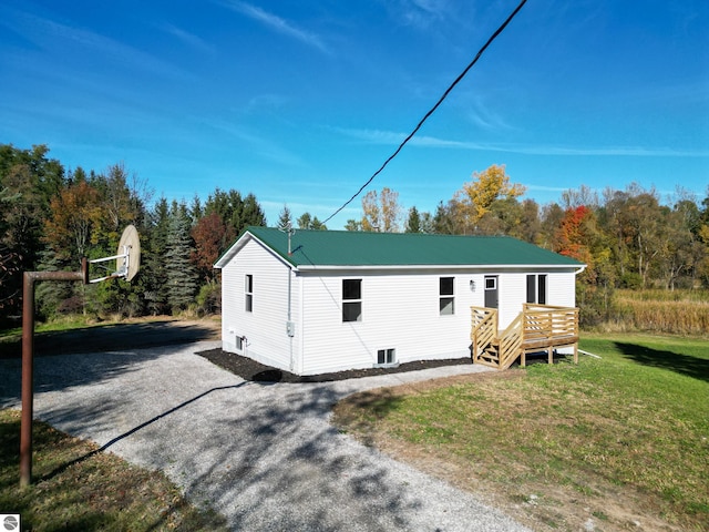 view of front of property with a front yard and a wooden deck