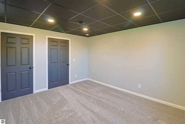 spare room featuring a paneled ceiling and carpet