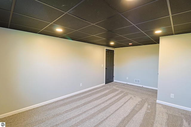 empty room with a drop ceiling and carpet flooring