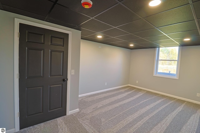 carpeted spare room featuring a drop ceiling