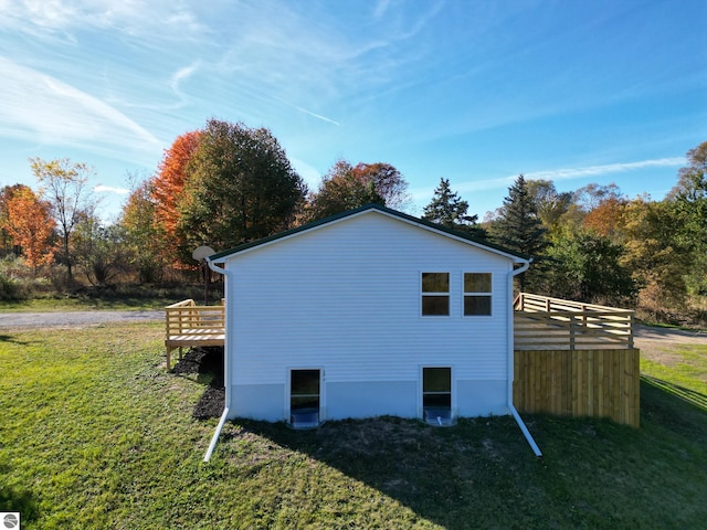 view of side of home featuring a yard and a wooden deck