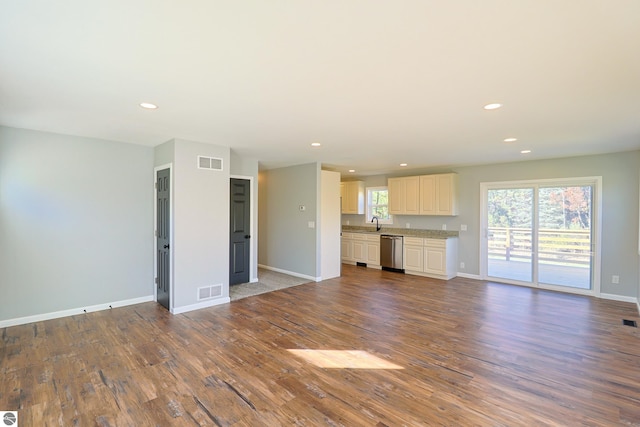 unfurnished living room featuring wood-type flooring and sink